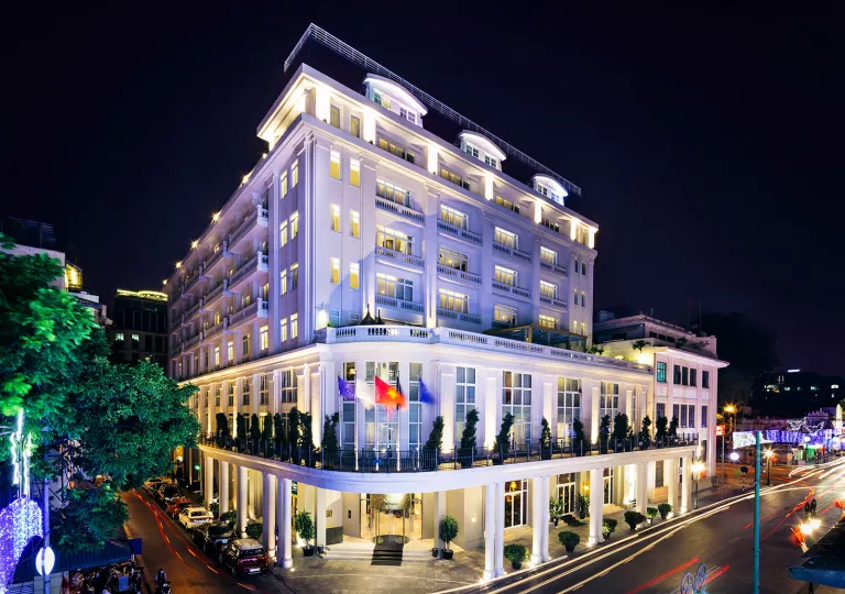 Exterior view of white, multi-story building with a road in front