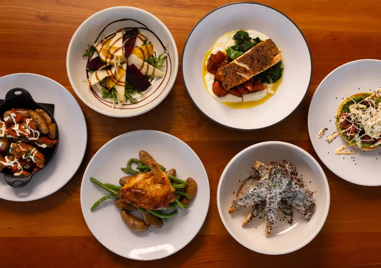 Plate of foods consisting of roasted chicken, fish and vegetables