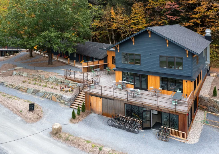 Gray and brown wooden building with an outdoor patio and bikes parked out front