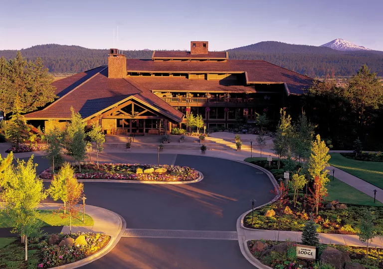 Exterior view of hotel building with a roundabout road and garden in front