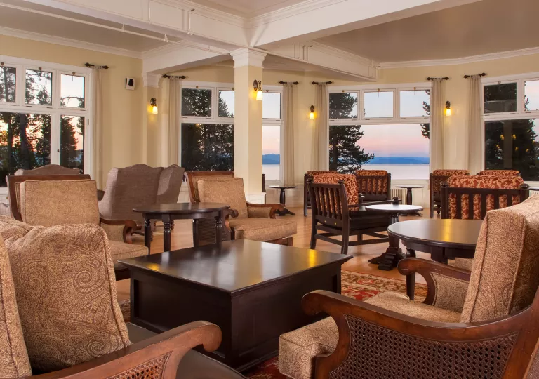 Indoor seating area and lounge with cushioned chairs and dark brown tables
