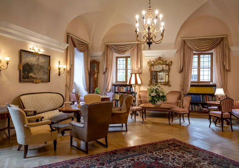 Indoor seating area and lounge with cushioned chairs and mini libraries along the wall