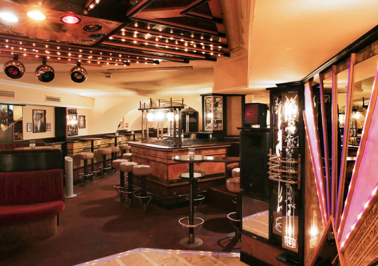 Bar and lounge with leather stools and dimly lit tables