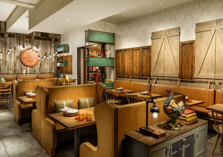 Dimly lit dining area with wooden booths and wooden dining tables