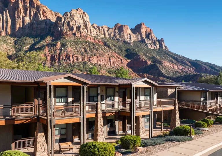 Exterior view of two-story hotel building with large stone pillars