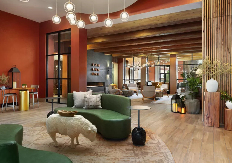 Indoor seating and lounge area with green sofas and art sculptures around the room