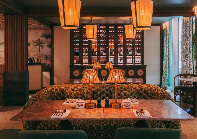 Lounge area with a large sofa and marble table, with warm illuminated lights