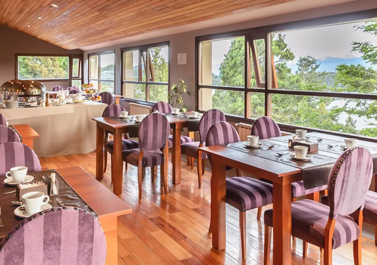 Dining area with square dining tables and red, cushioned chairs