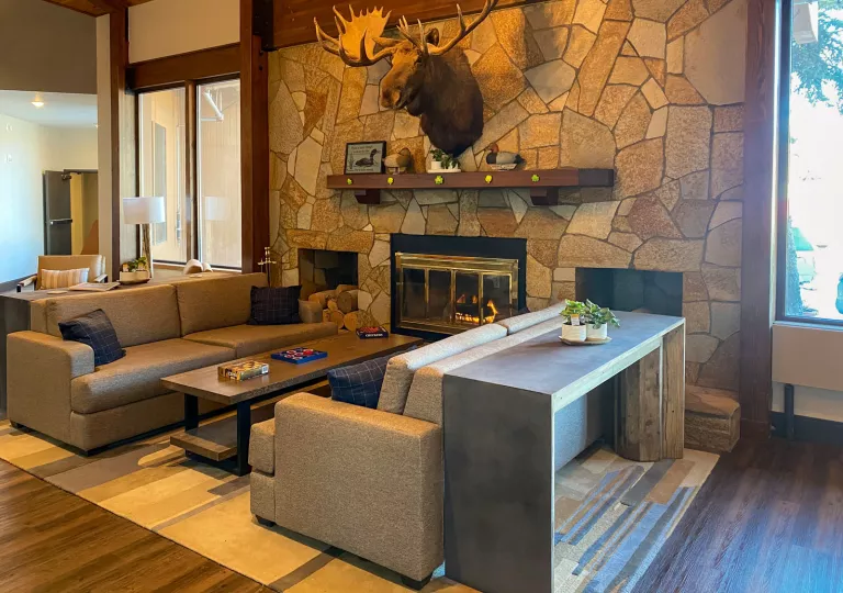 Stone wall with a fireplace and two beige couches in front