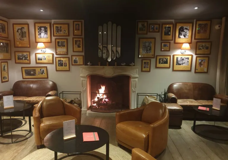 Dimly lit lounge area with leather couches in front of a fireplace