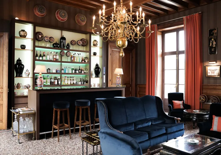 Bar and lounge with blue sofas and a bar counter with alcohol on shelves