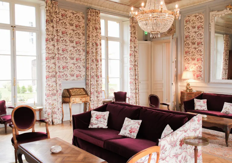 Room lobby with red, cushioned sofas and flower patterned curtains