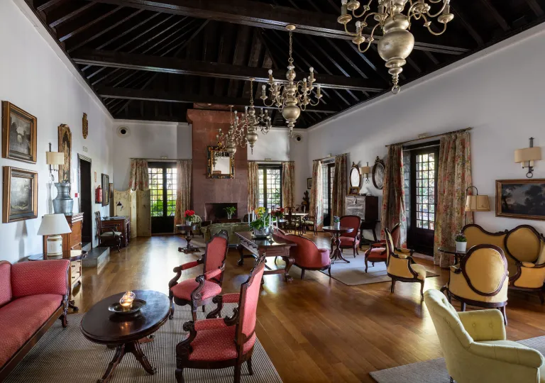 Lobby and lounge area with red and beige chairs surrounding small coffee tables