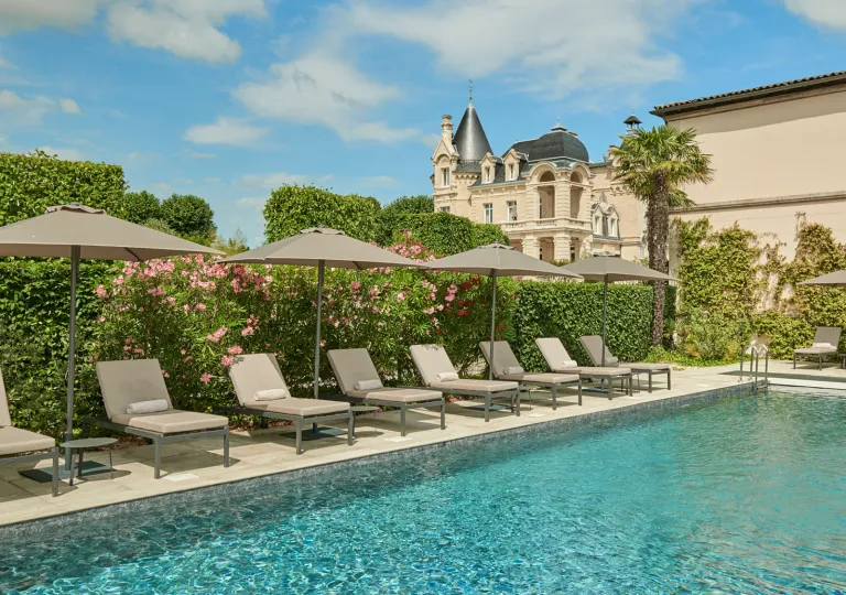 Outdoor pool surrounded by trimmed bushes