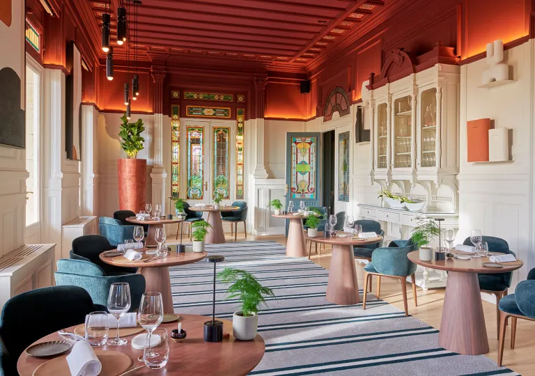 Lounge and dining area with circular tables and blue chairs