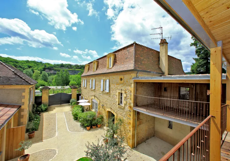 Exterior, 2nd-story view of a stone building with a large valley in the background