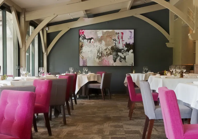 Restaurant with white dining tables and pink and gray chairs