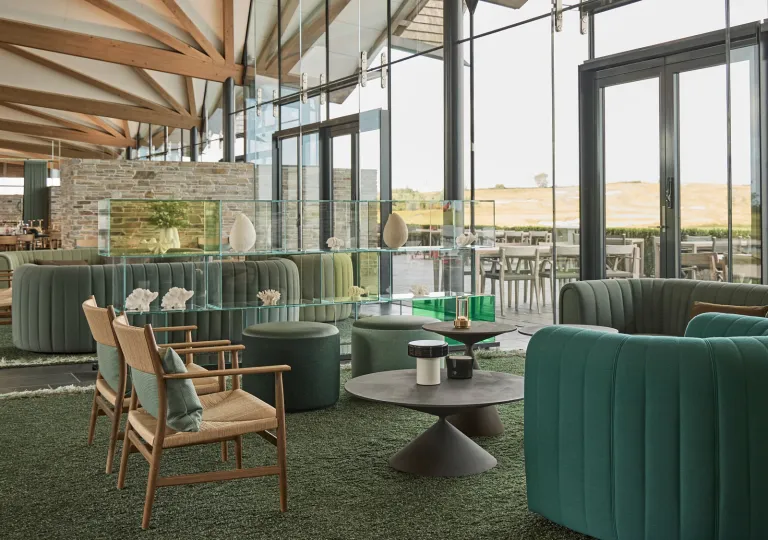 Lounge and seating area with cushioned chairs and large glass walls