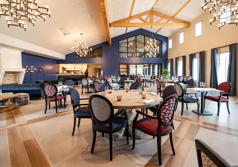 Restaurant area with circular tables and red and blue cushioned chairs