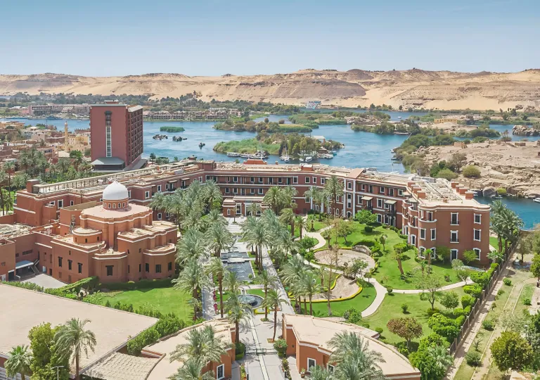 Aerial view of the historic complex of the Cataract Aswan nestled along the banks of the Nile.