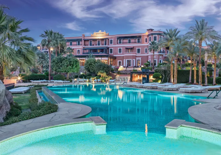 The large infinity swimming pool illuminated at dusk at the Old Cataract Aswan in Egypt.
