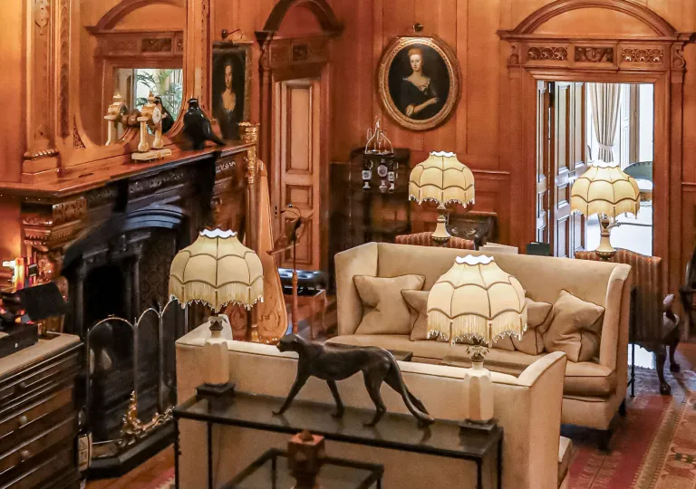 Room with antiques along the wall and 2 beige couches