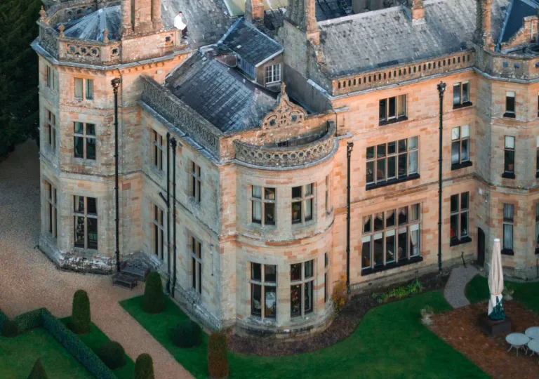 Aerial view of castle-like building with a trimmed lawn in front