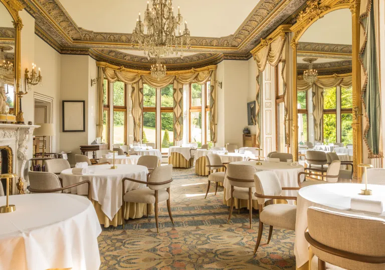 Dining area in a restaurant with circular dining tables and beige chairs