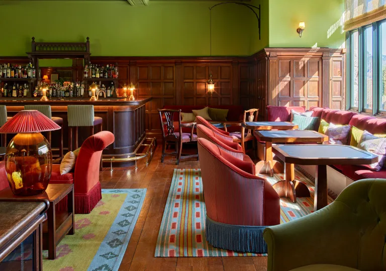 Restaurant with cushioned chairs surrounding square dining tables