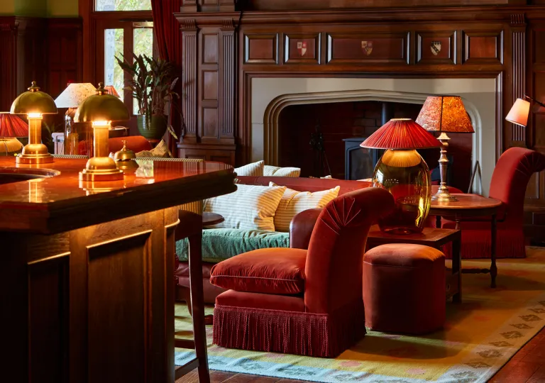 Lounge with cushioned chairs in front of a fireplace