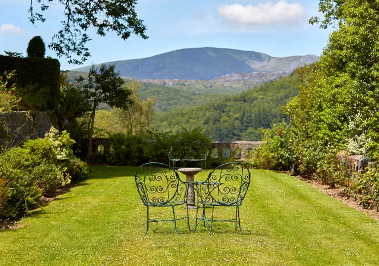 Large grass lawn with metal chairs and tables in the center