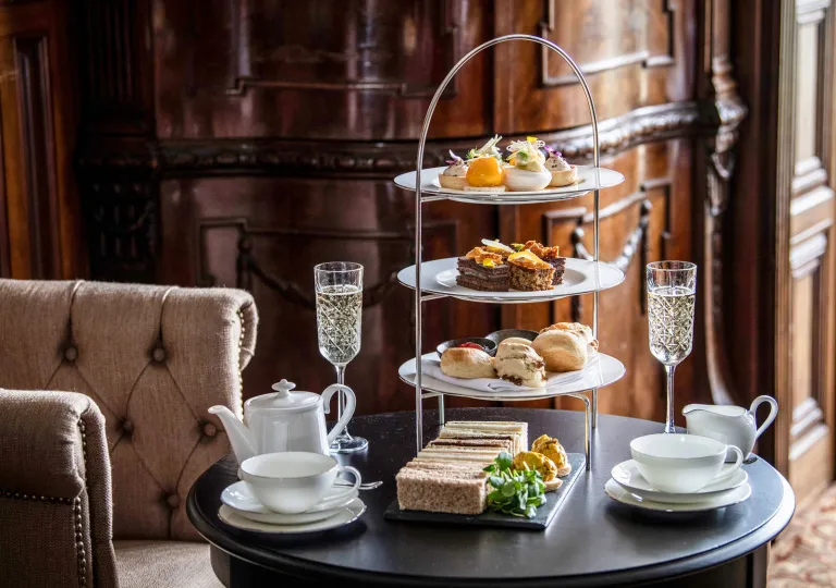 Circular table with a three-tier plate holder with pastries