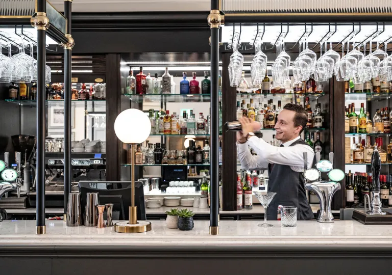 Bartender mixing a drink behind a bar counter