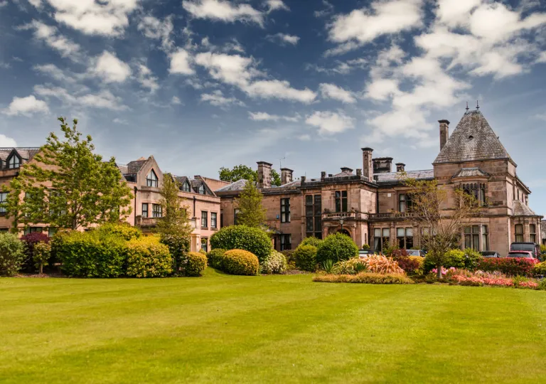 Exterior view of castle0like hotel building with a large lawn in front