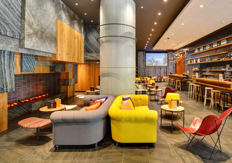 Lounge area with cushioned sofas next to large fireplaces