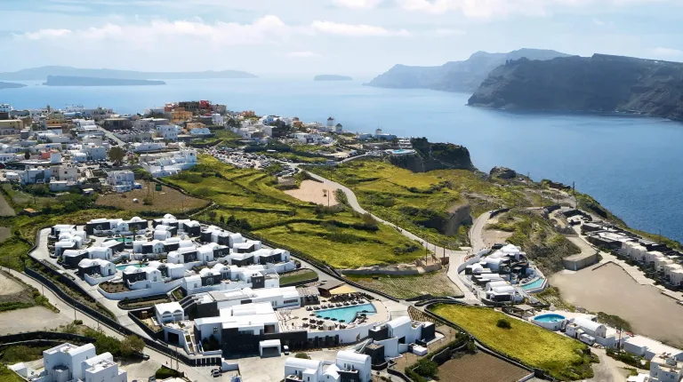 Overlook of Santo Pure Oia with rolling hills and a distant bay.
