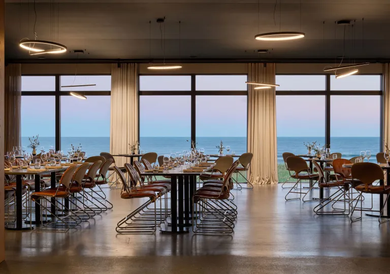ÓMUR restaurant inside the Black Sand Hotel in the Ölfus region in South Iceland  features an open-plan, minimalist dining space with floor-to-ceiling panoramic windows.
