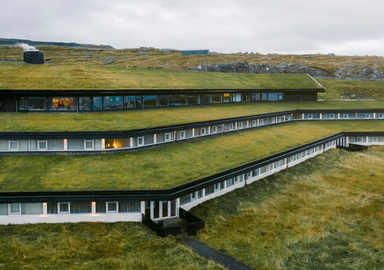 Exterior view of grass roofing over long, hotel buildings
