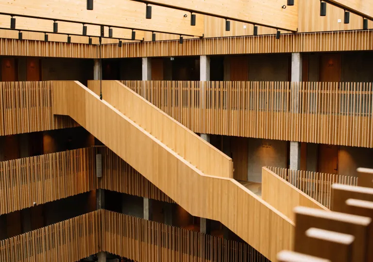 The modern interior of the KG Hotel in Klaksvík, Faroe Islands, which features a timber-clad staircase and acoustic slat walls.
