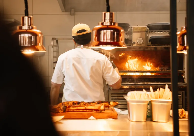 A chef working in the restaurant kitchen with a live-fire grill at the KG Hotel in Klaksvík, Faroe Islands.