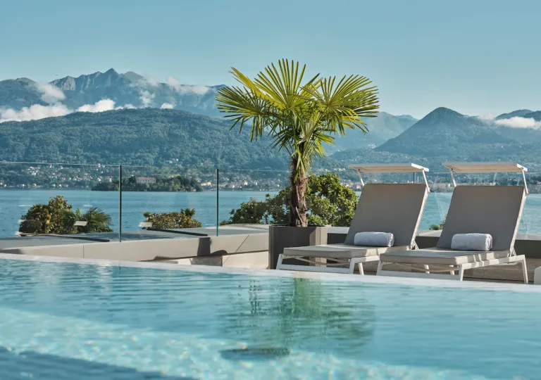 The rooftop panoramic infinity pool with modern sun loungers at the Boutique Hotel Stresa on the shores of Lake Maggiore.