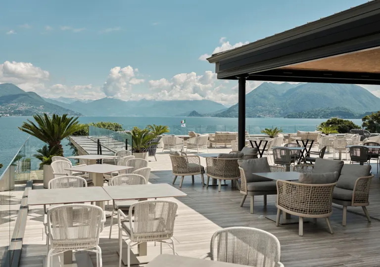 The rooftop terrace of the Boutique Hotel Stresa on Lake Maggiore, features contemporary white outdoor furniture and panoramic views.