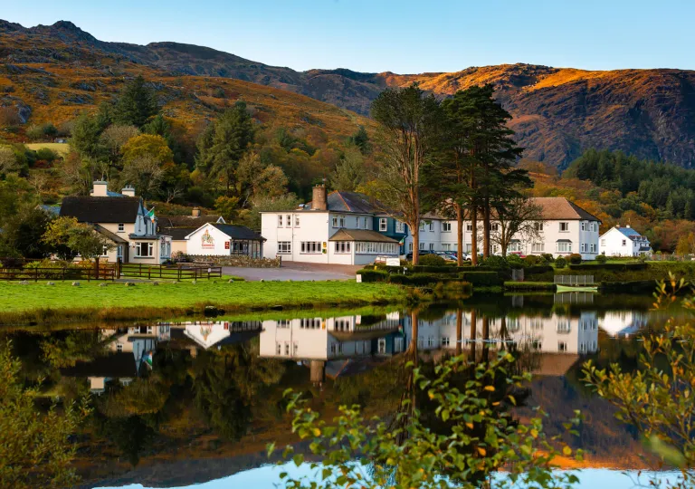 Exterior view of white buildings in front of a large lake
