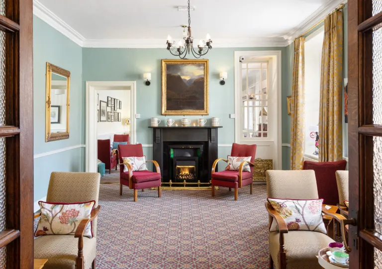 Living room area with cushioned chairs in front of a black fireplace