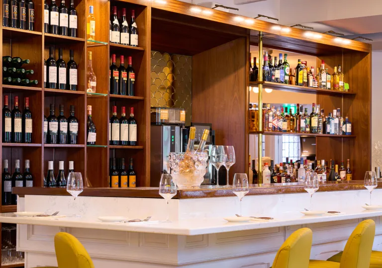 Bar counter with wooden shelves and bottles of wine