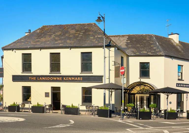 Exterior view of beige and gray building with a long road in front