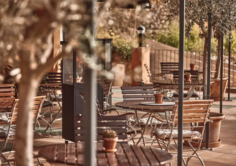 Outdoor patio with circular, wooden tables and chairs