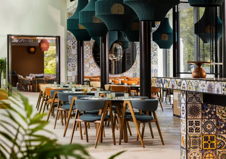 Dining area with gray, cushioned chairs surrounding circular dining tables