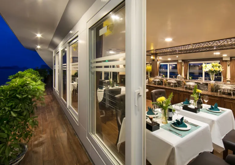 Cruise ship restaurant with white dining tables and large windows