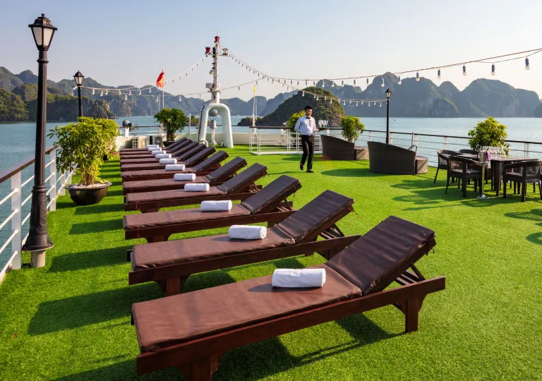 Cruise ship patio with turf lawn on top and rows of wooden chairs